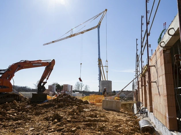 Chantier de construction extérieur avec plusieurs immeubles résidentiels en béton en cours d'édification