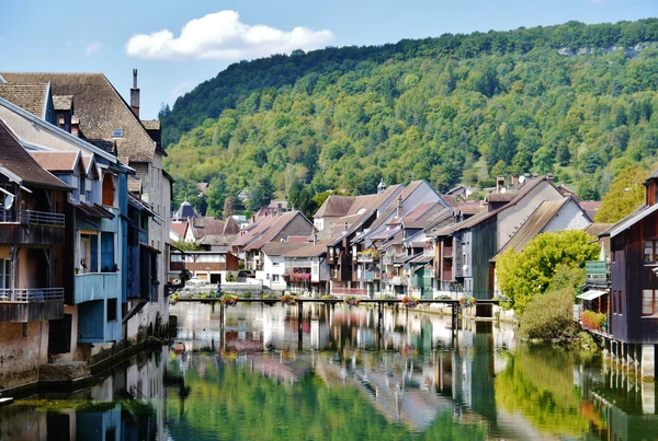 Photographie aérienne ou grand angle du village d'Ornans dans le Doubs, montrant son environnement urbain et naturel caractéristique. L'image doit capturer les éléments visuels distinctifs d'Ornans (architecture, rivière ou cours d'eau notable, paysage environnant), prise de jour avec une bonne luminosité, et offrir une perspective visuelle clairement différente des vues montagneuses et de confluence déjà sélectionnées pour les autres localités.