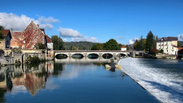 Photographie aérienne ou grand angle du village de Quingey dans le Doubs, montrant la confluence des rivières (Doubs et Loue), les falaises calcaires caractéristiques de la région, l'habitat villageois dispersé dans un paysage de vallée verdoyante. La photo doit être prise de jour avec une bonne luminosité et mettre en évidence la topographie distinctive de Quingey, différente de Dannemarie-sur-Crête, avec ses éléments géographiques naturels marquants.